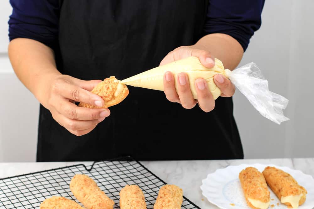 An overfilled éclair with pastry cream leaking from the sides